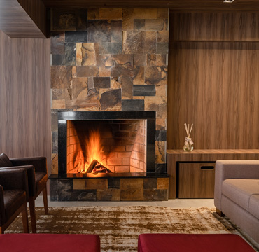 Recepção com lareira e TV Hotel Fioreze Centro Gramado